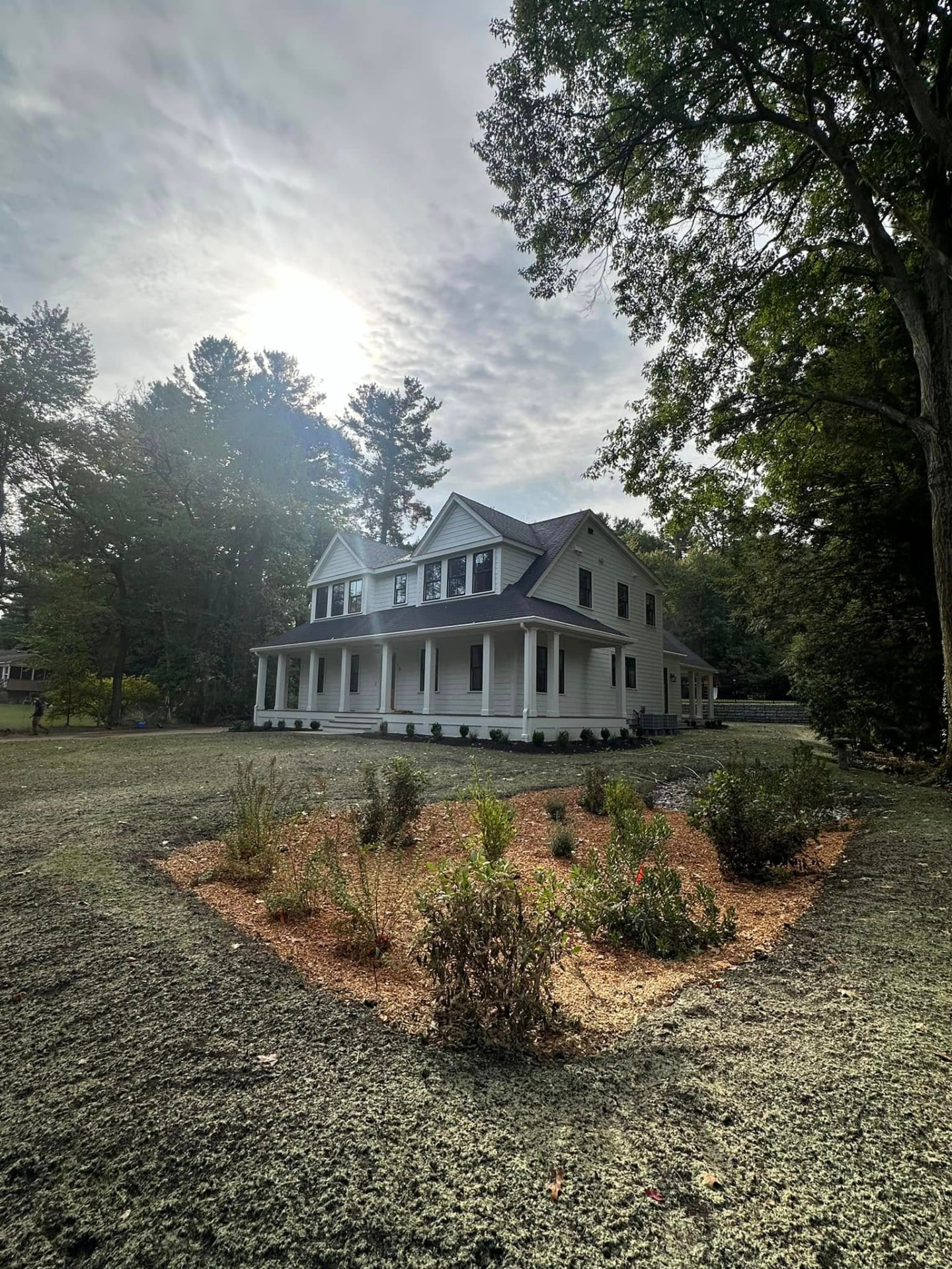 Freshly cleaned and planted garden bed beside a New England front walkway