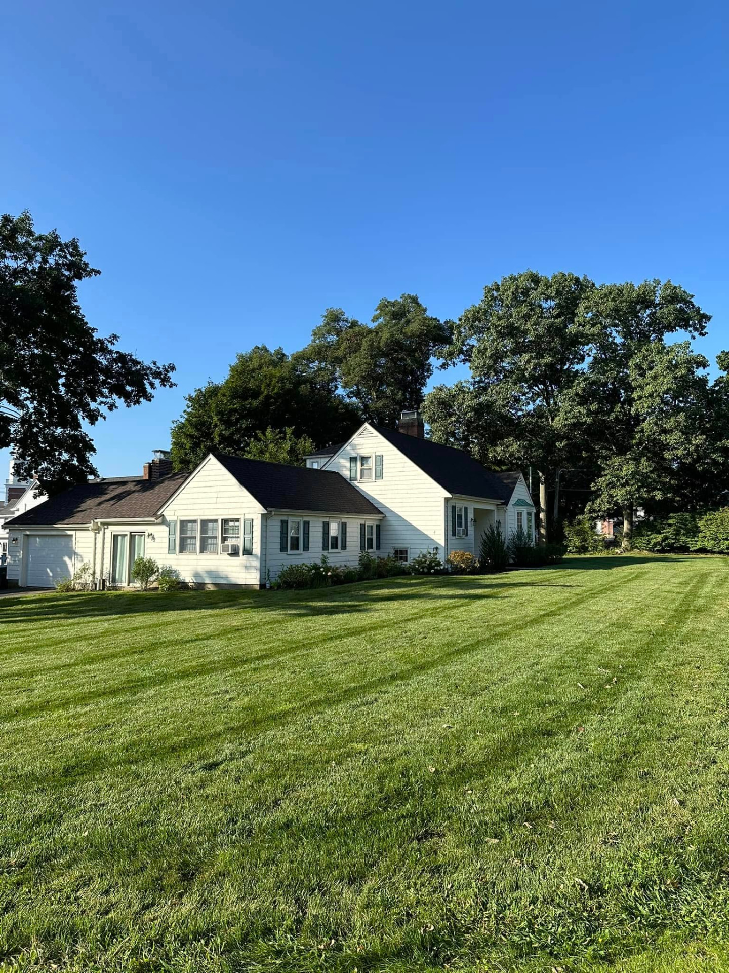 Striped green lawn in front of a Cape style home in Westwood, Massachusetts