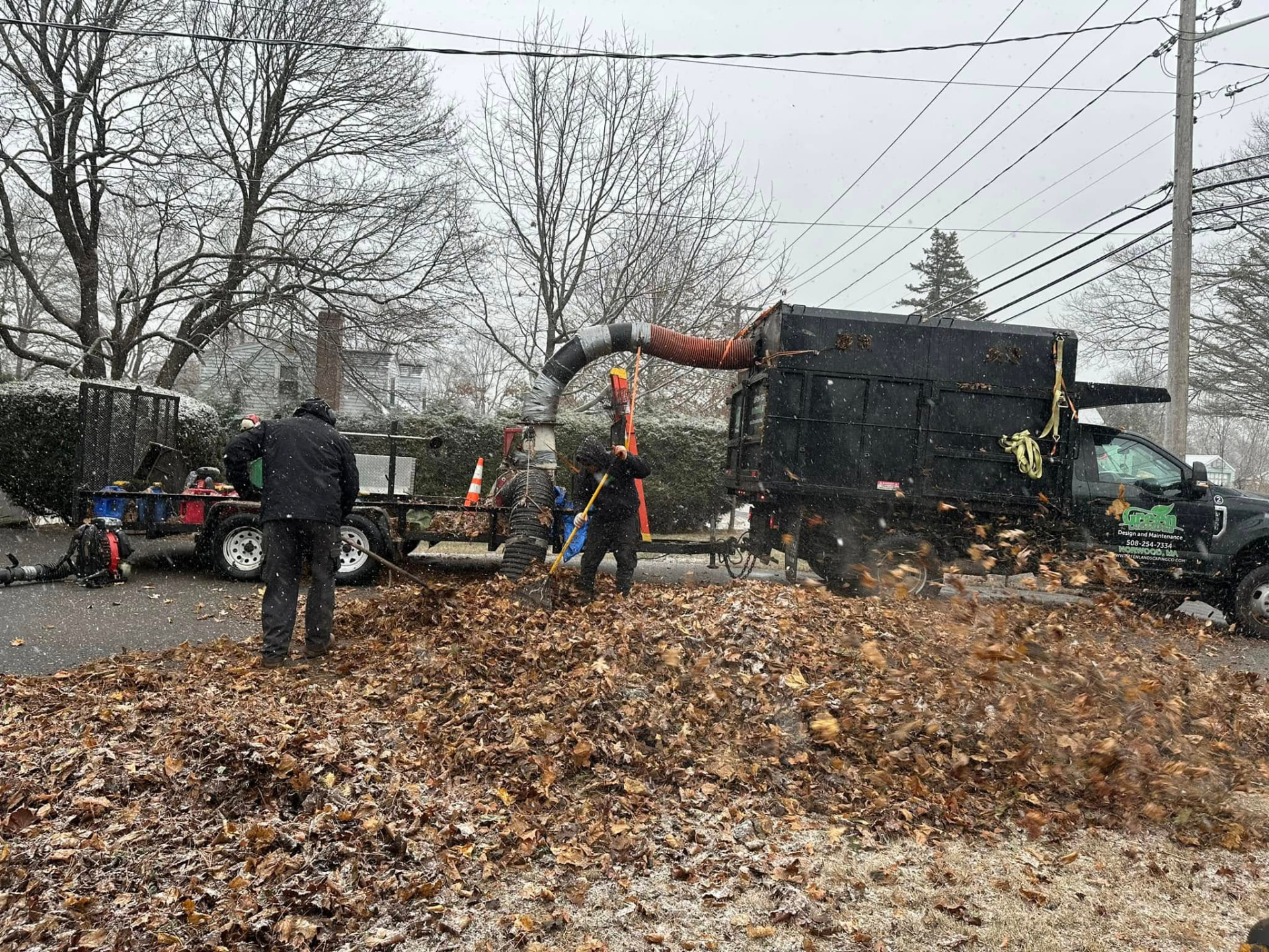 Green Landscaping crew working in early season snow in Norwood, Massachusetts